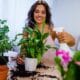 Caring for indoor plants. A woman happily spraying her plants