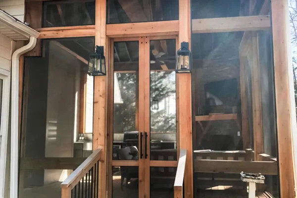 Screened-in porch with a fireplace and a grilling area