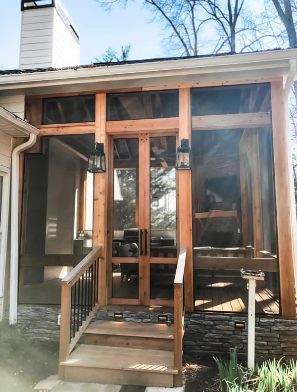 Screened-in porch with a fireplace and a grilling area