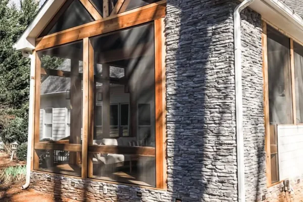 Screened in porch with a fireplace and a grilling area