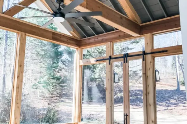 Screened-in porch with a fireplace and a grilling area