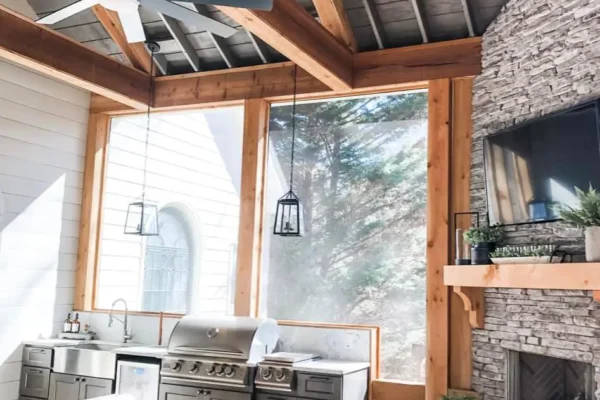 Screened-in porch with a fireplace and a grilling area